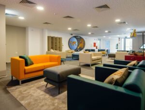 Common lounge of the Braga Youth Centre with colourful sofas and a world map on the wall