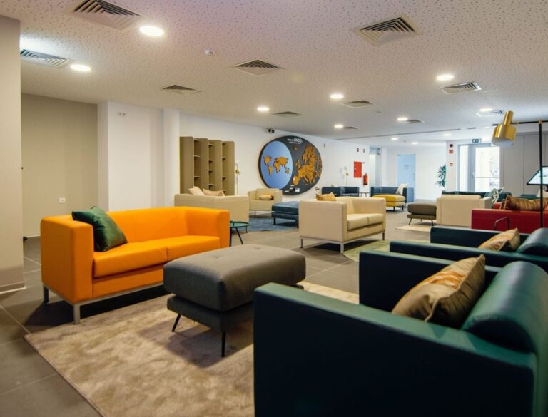 Common lounge of the Braga Youth Centre with colourful sofas and a world map on the wall